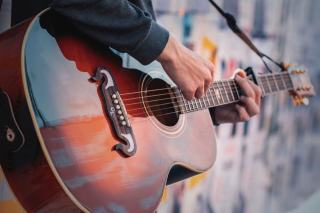 Photo d'illustration montrant guitariste blues avec tablature en main